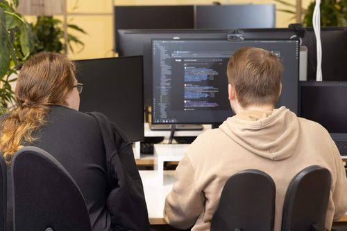 bluehands Mitarbeiter:innen bei der Besprechung eines Softwareprojekts Mitarbeiter:innen von bluehands besprechen ein Softwareprojekt am Computer