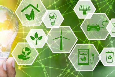 Man sieht mehrere Kacheln mit Symbolen in grün, z.B. Windrad, E-Auto, Solaranlage in grün, am Rand eine Hand mit Glühbirne