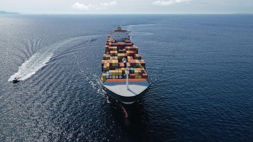 Containerschiff auf See mit Beiboot an der Seite